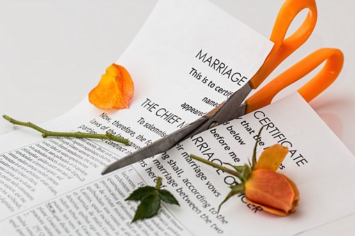 Pair of scissors cutting up marriage certificate